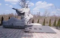 A concrete monument of a woman cradling a man.