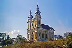 a large church structure with two towers on a hill