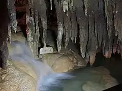 Underground waterfall inside the Cave, The stone marker identifies the feature as (地煙の滝) (Jien no Taki), meaning "Earth Mist Falls."