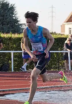 Photo of Jakob Ingebrigtsen after a water jump during a steeplechase race