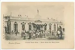 Black and white historic postcard of "Marta Abreu" station, circa 1900. People gathered outside the main gates.