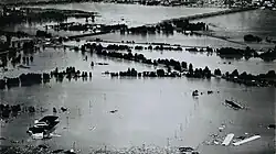 Aerial view of remnants of a populated area inundated by a flood.