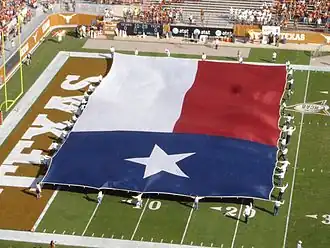 Large Texas flag at a football game.
