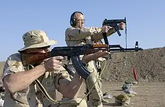 An American Air Traffic Control Detachment range officer fires an MP5K at the Baghdad International Airport firing range.