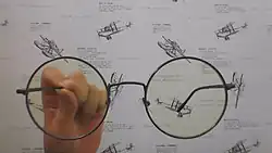 A Silhouette Frame In Someones Hand With Blue Cut Lensess