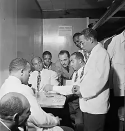Al Sears, Shelton Hemphill, Junior Raglin, Django Reinhardt, Lawrence Brown, Harry Carney, Johnny Hodges at the Aquarium Jazz Club on 52nd Street in Manhattan, ca. November 1946
