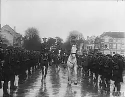 Albert I and Jeudwine on horseback, ride between two rows of troops from the division.