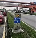 An old-style kilometre marker stone at the SkyPark Terminal with 9 kilometres towards Sungai Buloh.