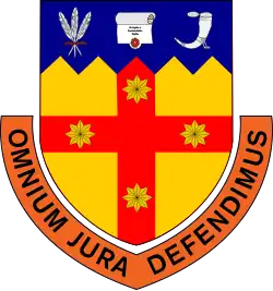 A shield of arms showing four 8 pointed stars on a cross along with a scroll, quill pens and an inkwell