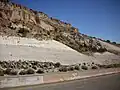 Road cut exposing Otowi Member in Pueblo Canyon. Above are cliffs of Tsherige Member.