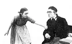 A young woman grabs the arm of an older man