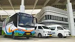 A Big Bird shuttle bus parked right next to two Damri Toyota Hiace shuttle vans at the Tegalluar Station in Bandung