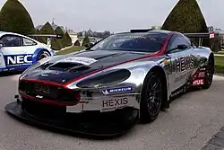 DBRS9 in white with a large, black spoiler, covered with livery, on the track.