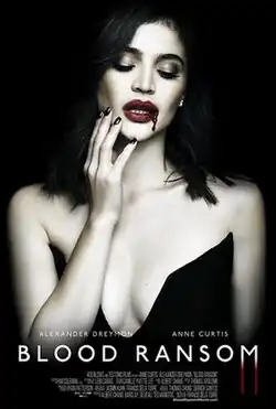 A white woman with flowing black hair wearing red lipstick and black dress touches blood coming from her lips.
