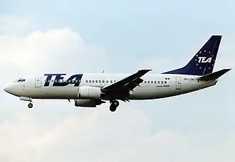 A white and blue Boeing 737 with 'TEA' written on its side and tail