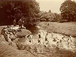 In England, boys swimming nude and girls in suits (1910)
