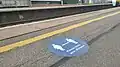 An outdoor vinyl sticker promoting social distancing on platform 1.