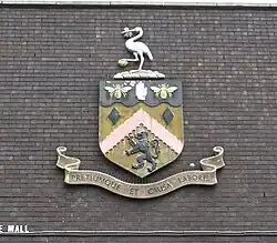 The coat of arms of Burnley with an inscription on the bottom reading "Pretiumque et causa laboris"