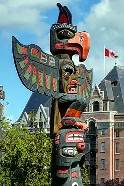 A multi-coloured pole with three faces and two sets of wings.