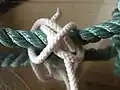 C : Complete the overhand knot with the main line under both riding turns, entering from left