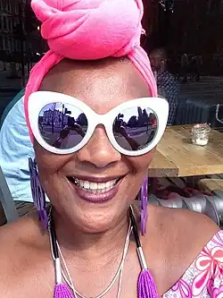 A photograph of Carol Leeming smiling and wearing glasses