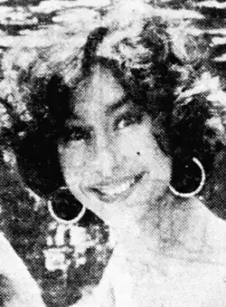 A 22-year-old woman with dark hair smiling at the camera