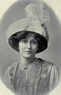 A young white woman wearing a large plumed hat, in an oval frame.