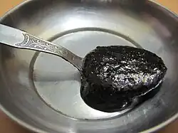 Thick, dark liquid on a spoon