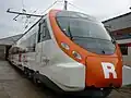 The front side of a Civia train. A big 'R' (standing for Rodalies de Catalunya) is painted on the front.