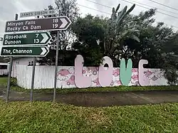 LOVE in Clunes, New South Wales, featuring directional signs to surrounding areas, 2025