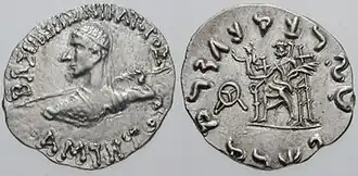 Another silver coin of Amyntas. The obverse shows the king's portrait holding a spear, with surrounding Greek legend. The reverse shows seated Zeus holding Athena, and with surrounding Kharoshti legend.