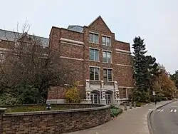 A four-story brick building in Collegiate Gothic style