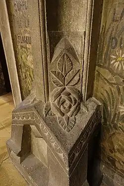 Molded concrete flower on the base of a pillar