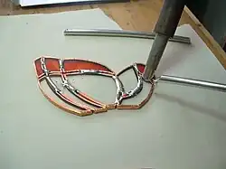 Pieces of glass are wrapped in copper tape and then soldered.