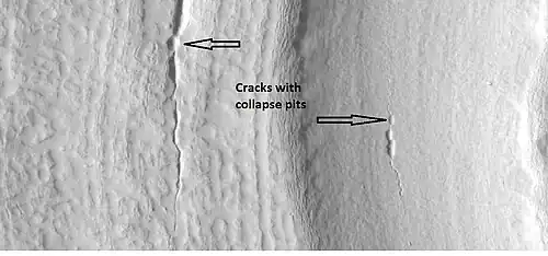 Close-up that shows cracks containing pits on the floor of a crater containing concentric crater fill, as seen by HiRISE under HiWish program. Location is Casius quadrangle.