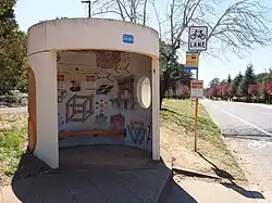Colour photograph of a bus shelter with paintings inside of it