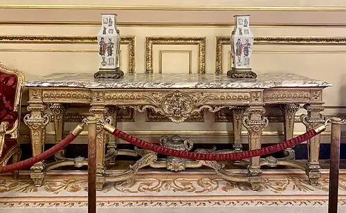 Large console with central projection; by Benjamin Deguil and Benjamin-Paul Ramillon; 1850–1875; gilt wood and marble; 100 x 283 x 77 cm; Napoleon III Apartments, Louvre Palace, Paris[170]