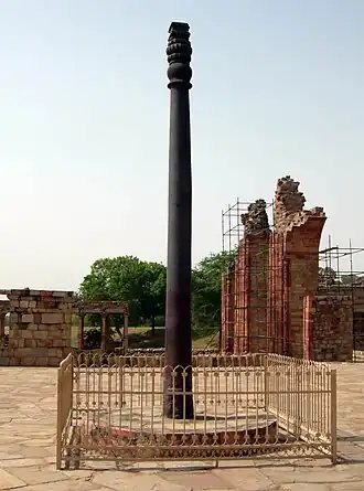 A tall, visibly old, decorative iron pillar without rust
