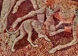 alt:a small dog with lean ears is pictured biting a deer.