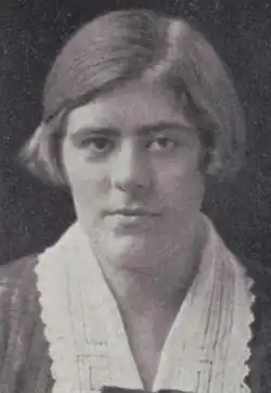 A young white woman with light hair cut in a bob, wearing a wide white collar with lace trim