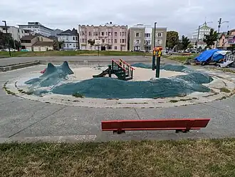 The small sand playground at Wilma Chan Park is encircled by a concrete dragon