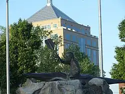 WIS 52 crossing the Wisconsin River, with a kayaking statue in the park and the Dudley Tower in the background
