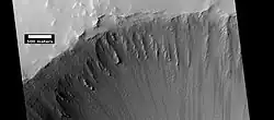 Crater at the top of Ulysses Patera, as seen by HiRISE under HiWish program Note the lack of a rim. Volcanic craters do not usually have a rim, as most impact craters do.