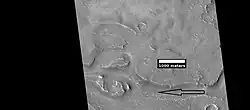 Close view of streamlined shapes, as seen by HiRISE under HiWish program. Arrow indicates the direction of past flowing water.