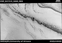 Wide view of spring defrosting. The dark spots are where the ice has disappeared, thus revealing the dark surface beneath the ice. Picture taken with HiRISE under HiWish program.