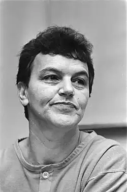 Woman with short-dark hair wearing a button front tee-shirt