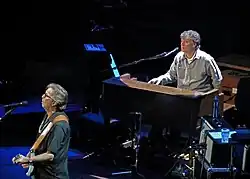 Eric Clapton on guitar and Steve Winwood on keyboards performing together on stage