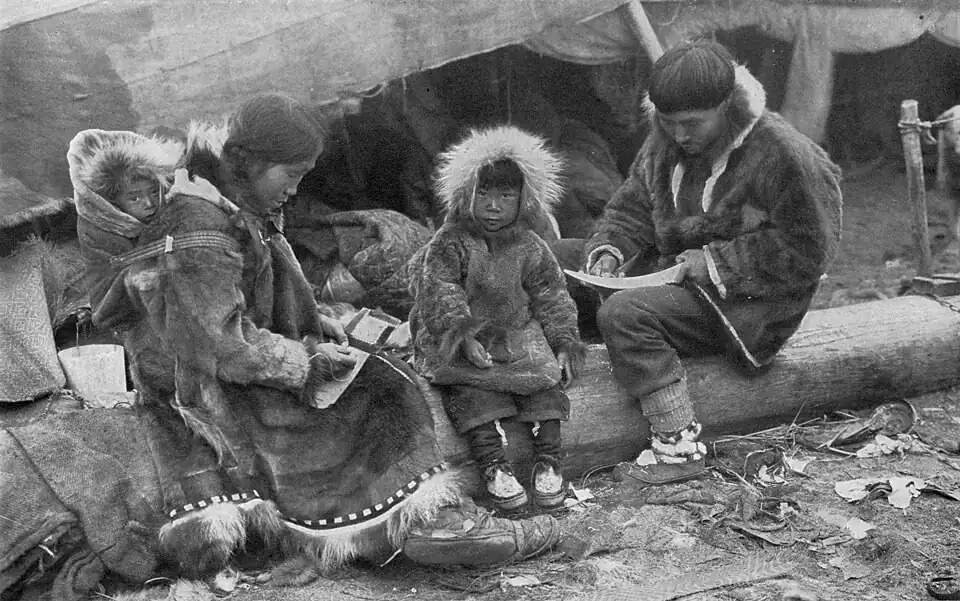 An Inuit family wearing traditional caribou parkas