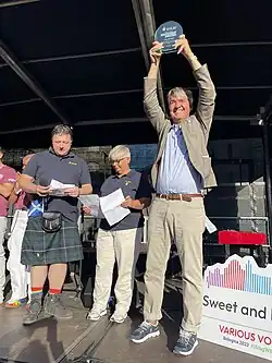 openning stage at the with 3 standing figures of officials and organizers behind