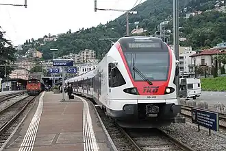 White-and-red train on tracks next to platform
